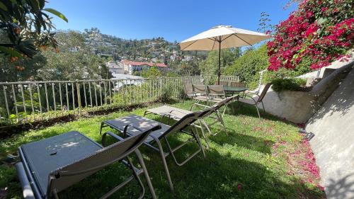 een groep stoelen en een paraplu in een tuin bij Glamping Hollywood Hills - Luxury Tiny House in Los Angeles