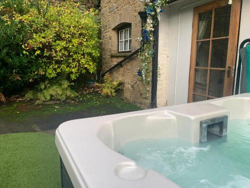 a bath tub in the backyard of a house at Coach House in Keighley