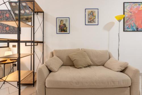 Locanda del buongustaio في كالياري: غرفة معيشة مع أريكة ولوحات على الحائط