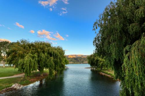 a river with trees on the side of it at Marsden Lake Resort Central Otago in Cromwell