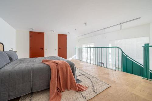 a bedroom with a bed with an orange blanket on it at Bright designer Loft in the city center in Rīga