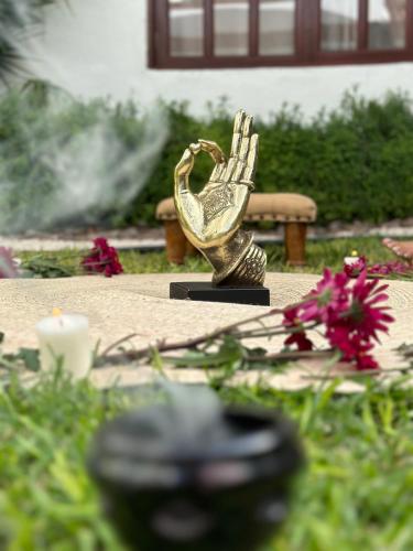 a gold statue of a hand holding a heart at Dos Patios Querétaro Curamoria Collection in Querétaro