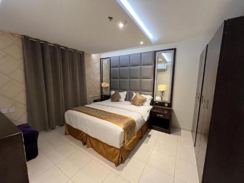 a bedroom with a large bed and a mirror at برج سما للشقق المفروشة in Jeddah