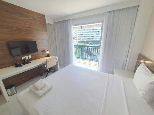 una habitación de hotel con una gran cama blanca y una ventana en Vision Executive Express III, en Brasilia