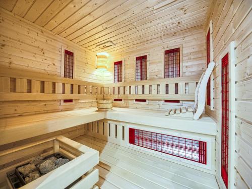 una sauna con paneles de madera y ventanas rojas en VisitZakopane - My Deer Apartment en Zakopane