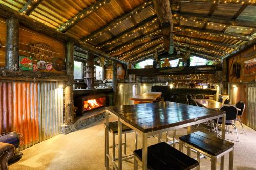 a dining room with a table and a fireplace at Marsden Lake Resort Central Otago in Cromwell