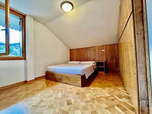1 dormitorio con cama y ventana grande en Su In Cima - Piancavallo, en Piancavallo