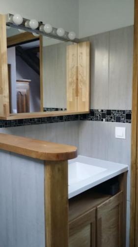 une cuisine avec des armoires en bois et un comptoir blanc dans l'établissement Gîte des Avaux- prés de Paris, à Champcueil