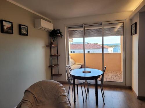 d'un salon avec une table et une vue sur un balcon. dans l'établissement Magnifique appartement, à Salon-de-Provence