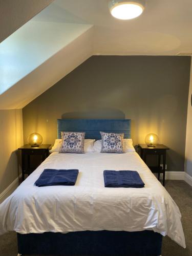 a bed with two blue pillows on top of it at The Fountain Inn & Riverside Restaurant in Okehampton