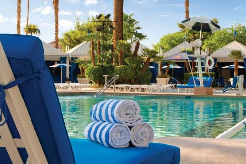 a blue chair with rolled towels sitting next to a swimming pool at Horseshoe Las Vegas formerly Bally's in Las Vegas