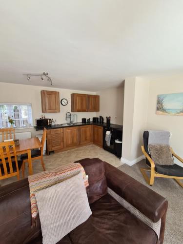 a living room with a couch and a kitchen at Resthaven Cottage in Mablethorpe