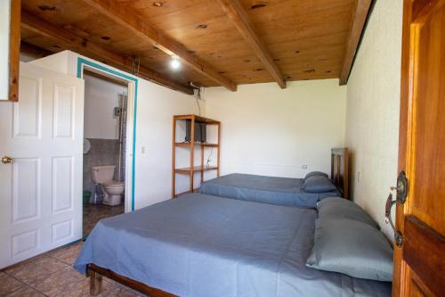a bedroom with two beds and a toilet in it at Hotel y Rest. las Cristalinas in San Pedro La Laguna