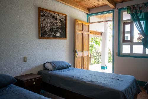 a bedroom with a bed and a door with a window at Hotel y Rest. las Cristalinas in San Pedro La Laguna