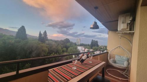 un balcón con 2 pájaros sentados en una mesa con copas de vino en RECUERDAME en Mendoza