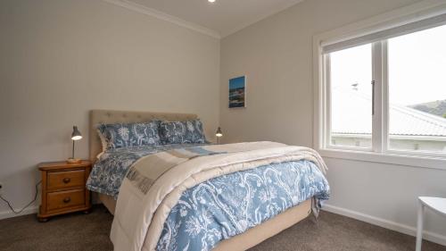 a bedroom with a bed and a window at Spacious Sunny Family Home in Akaroa in Akaroa