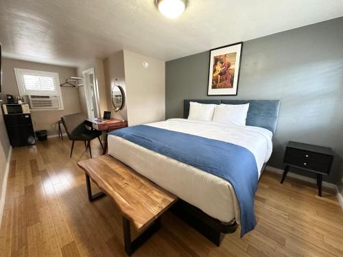 una camera da letto con un grande letto con una coperta blu di Ashland Motel - Oregon ad Ashland