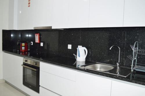 a kitchen with a sink and a black counter top at Market Apartment - VPA in Vila Praia de Âncora