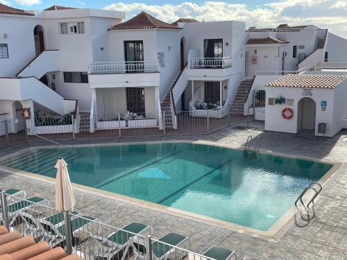 una gran piscina frente a un edificio en Luxury Diamond - Ocean view, Big terraces, Air Con, Wifi, en Los Cristianos