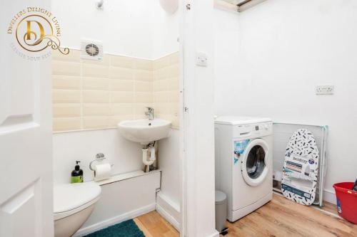 a bathroom with a sink and a washing machine at Basildon 3 - 4 Bedroom Property - Essex in Basildon