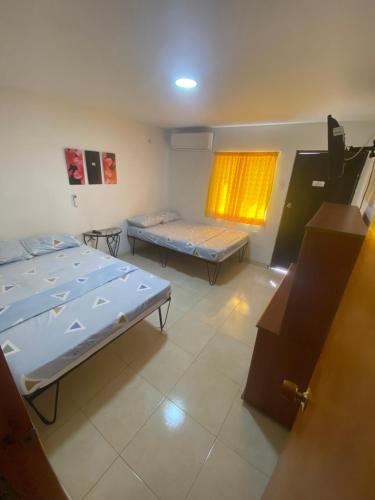 a room with two beds and a window at La Casona 42 in Barranquilla