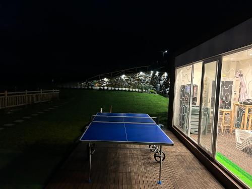 Biescas的住宿－La Salina - Complejo Turistico Rural CaleaCabo，夜间在大楼里的一个蓝色网球场