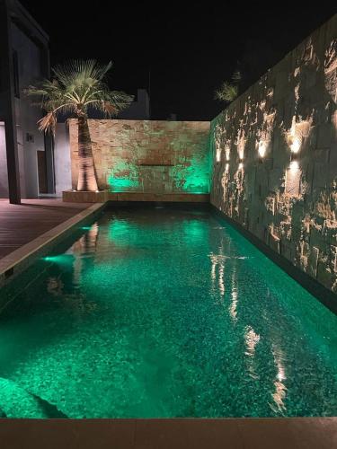 納沃華的住宿－RIVI GRAND HOTEL，夜晚带绿灯的游泳池