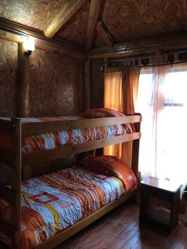 1 dormitorio con 2 literas y ventana en Cabaña el Ciprés, en Hornopirén
