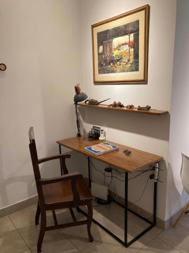 escritorio con silla y una foto en la pared en departamento tres cerritos en Salta