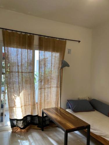 Habitación con sofá, mesa y ventana en departamento tres cerritos en Salta