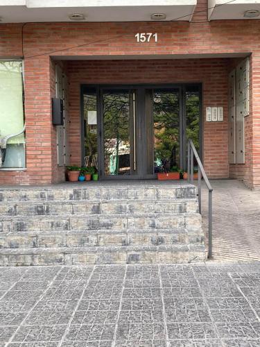 un edificio de ladrillo con una escalera delante de una puerta en departamento tres cerritos en Salta