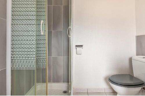 a bathroom with a toilet and a glass shower at Le 7 in Sète