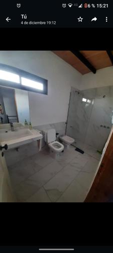 y baño con lavabo, aseo y espejo. en Casa Nueva en Villa Rumipal