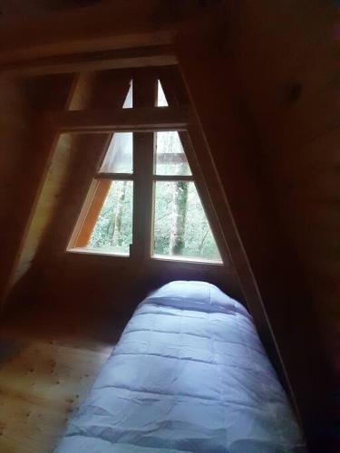 a bed in a room with a window at Casa Aurora in Puerto Fuy