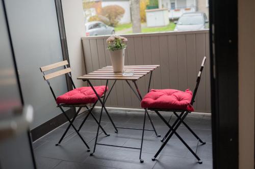 a table with two chairs and a vase of flowers on a balcony at Loft Riva II in Hamm