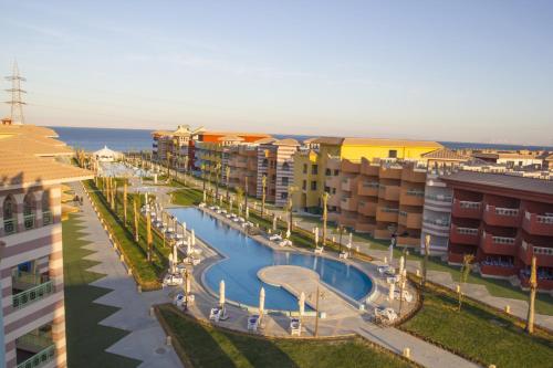 an apartment complex with a swimming pool and buildings at Porto South Beach by Amer Group - Families only in Ain Sokhna