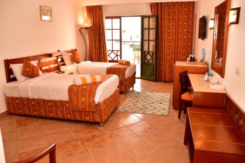 una camera d'albergo con 2 letti e una scrivania di Verginia Sharm Resort & Aqua Park a Sharm El Sheikh