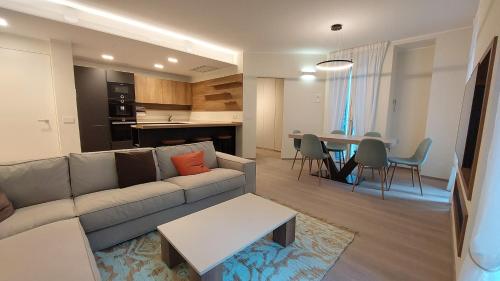 a living room and kitchen with a couch and a table at Cressoni Apartment in Como