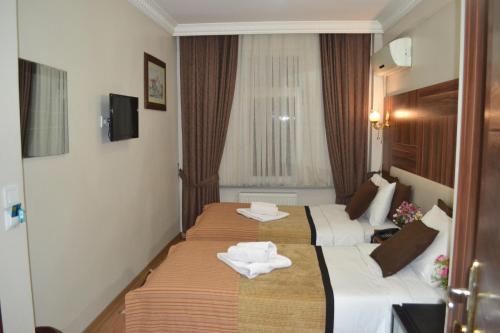 イスタンブールにあるGrand Fatih Hotelのホテルルーム内のベッド2台(タオル付)