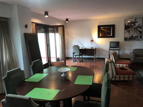 sala de estar con mesa de madera y sillas en Casa 3 ambientes 3 baños en Mar del Plata