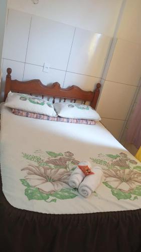 a bed with two folded towels on top of it at suites guaruja Ferry Boat in Guarujá