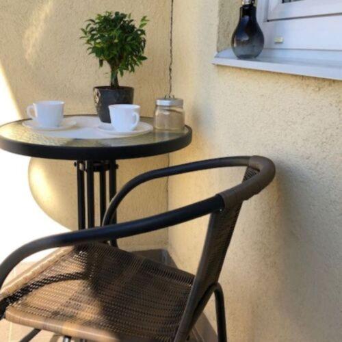 a chair sitting next to a small table with a plant at Bóbita Apartman in Zalakaros
