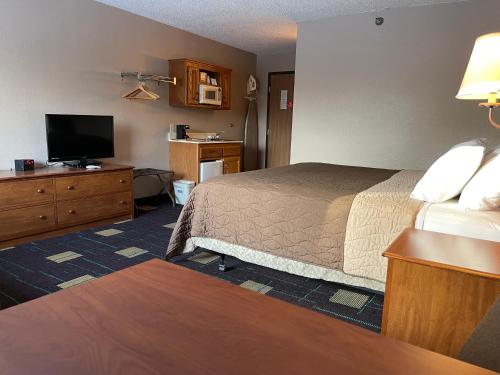 a hotel room with a bed and a flat screen tv at Walker Hotel in Walker
