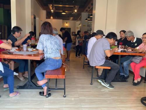 un grupo de personas sentadas en mesas en un restaurante en THE-SOMERSET INN & RESTAURANT, en Iloilo City