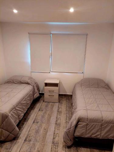 - une chambre avec 2 lits et une fenêtre dans l'établissement Departamento playa bonita Bariloche, à San Carlos de Bariloche