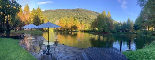 a table with two umbrellas sitting on a dock in a lake at Grace Garden Villa in Fengshan