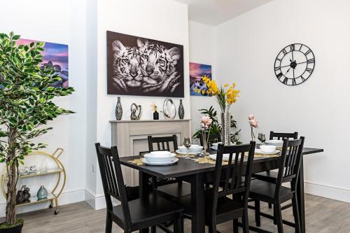 a dining room with a black table and chairs at Warwick West in Barrow in Furness