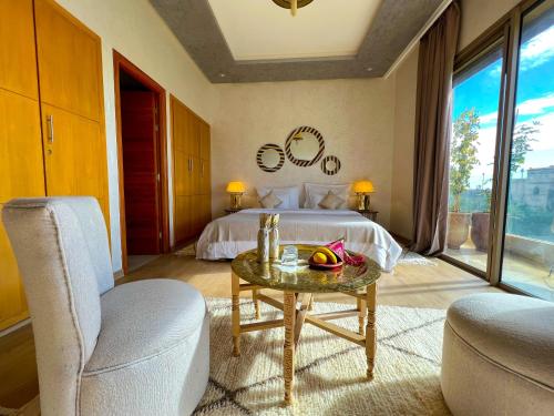 a bedroom with a bed and a table and chairs at Riad villa saphir & SPA in Marrakech