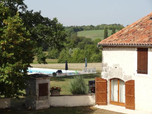 uma casa branca com uma piscina ao fundo em La Chillaudie em Verteillac