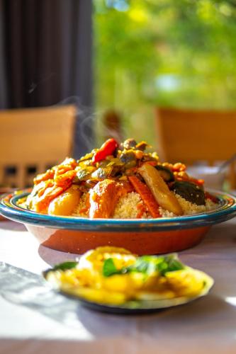 a bowl of food on a table with a plate of food at Riad villa saphir & SPA in Marrakech